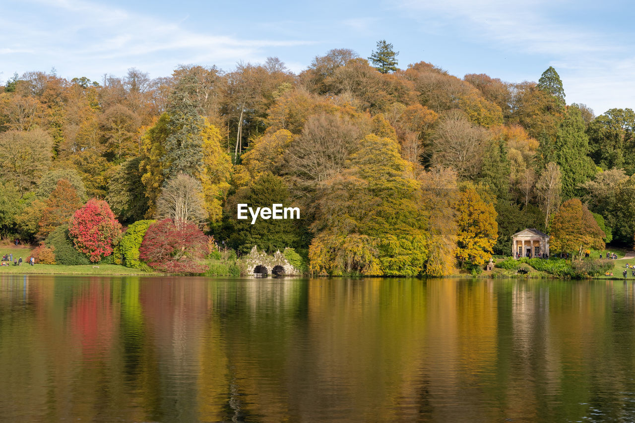 View of the autumn colours around the lake at stourhead gardens in wiltshire.