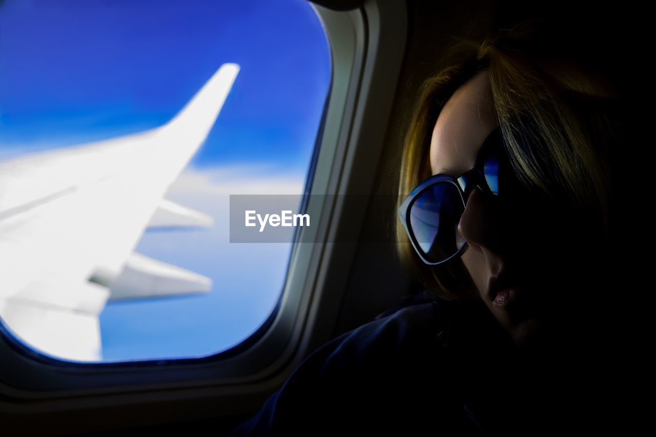 Close-up of woman sitting by airplane window