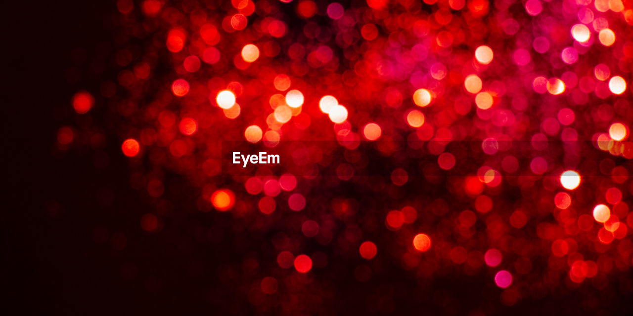 Defocused image of illuminated red lights at night