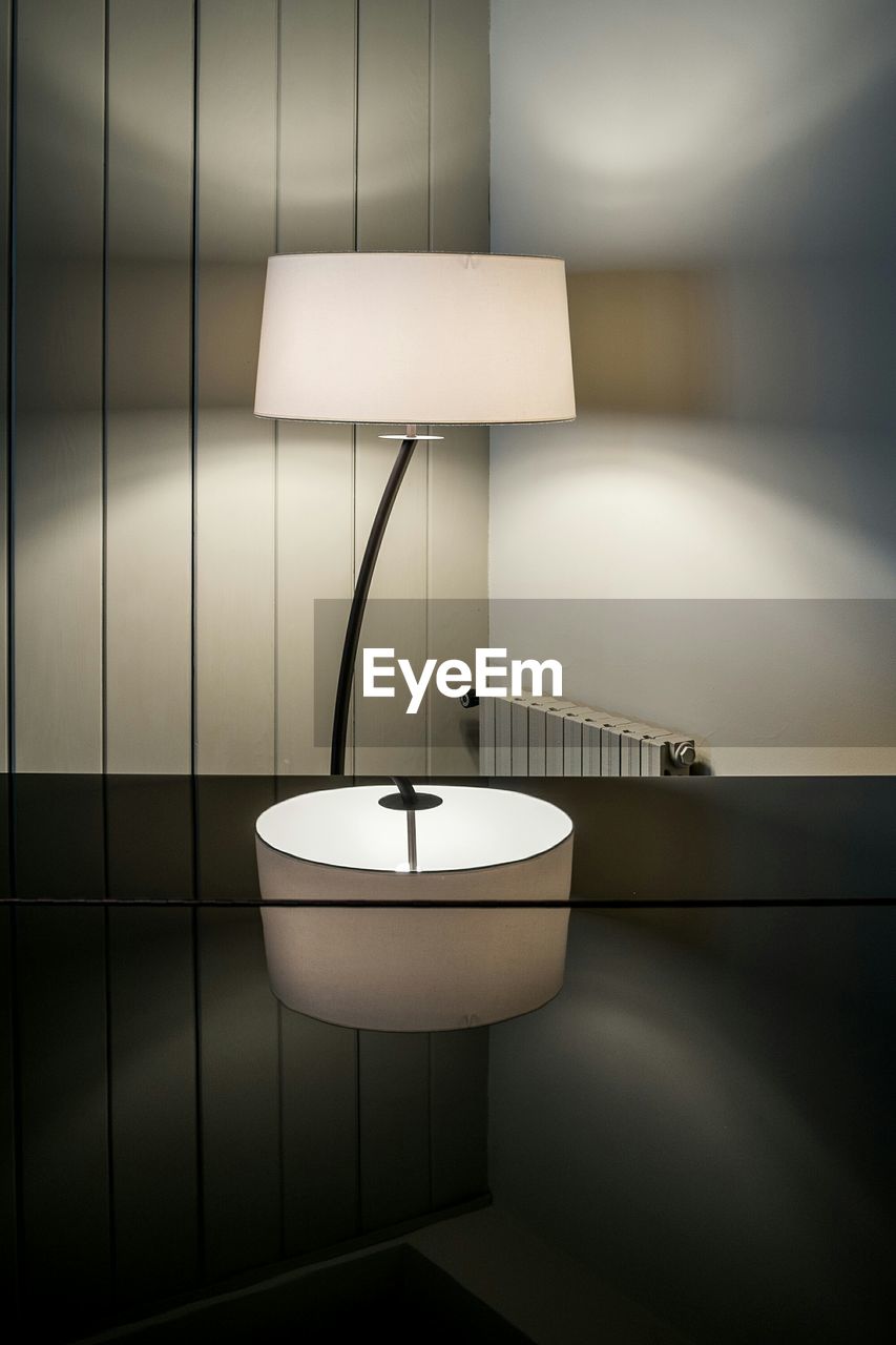 Illuminated lamp by table at home