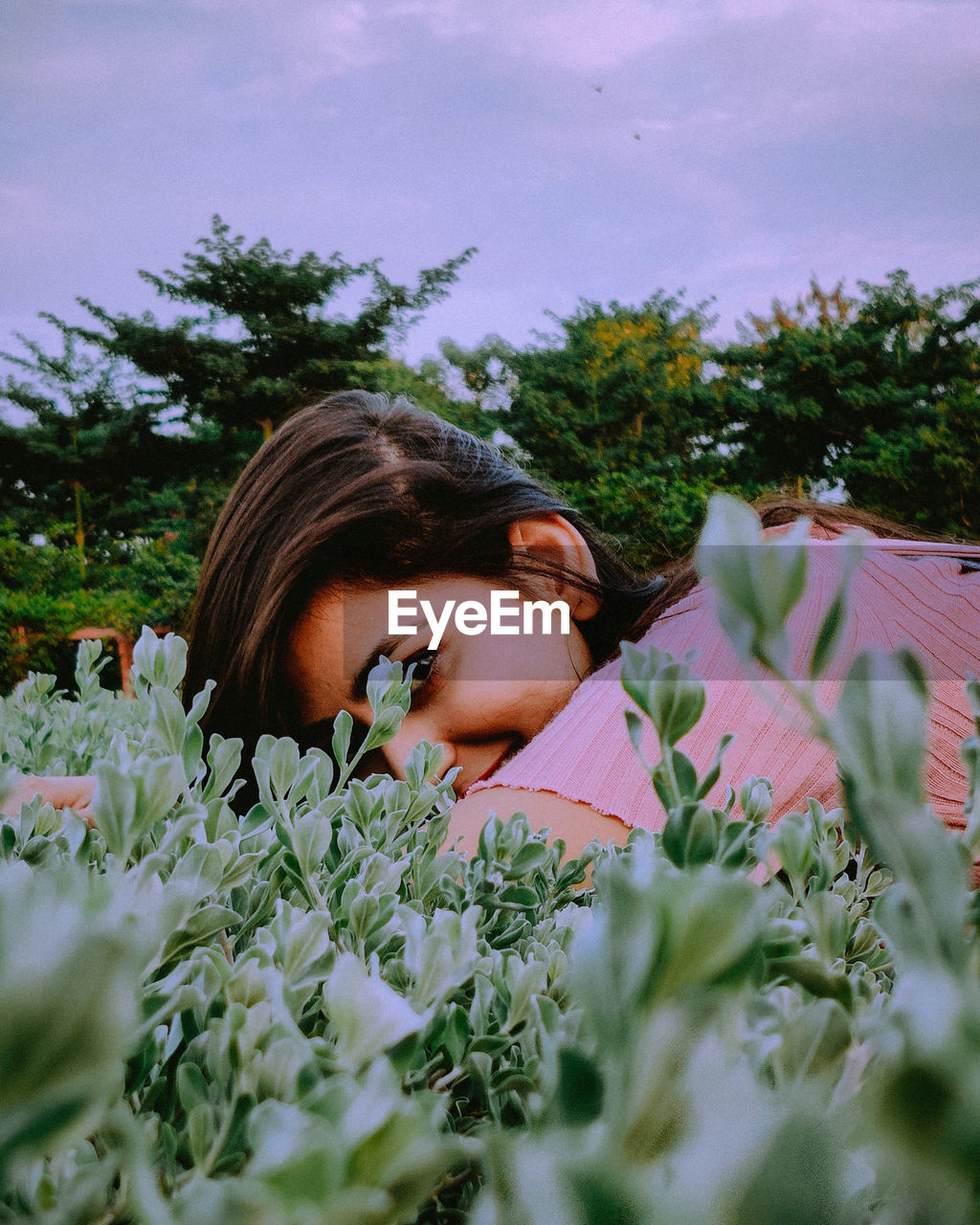 Portrait of woman lying down on plants