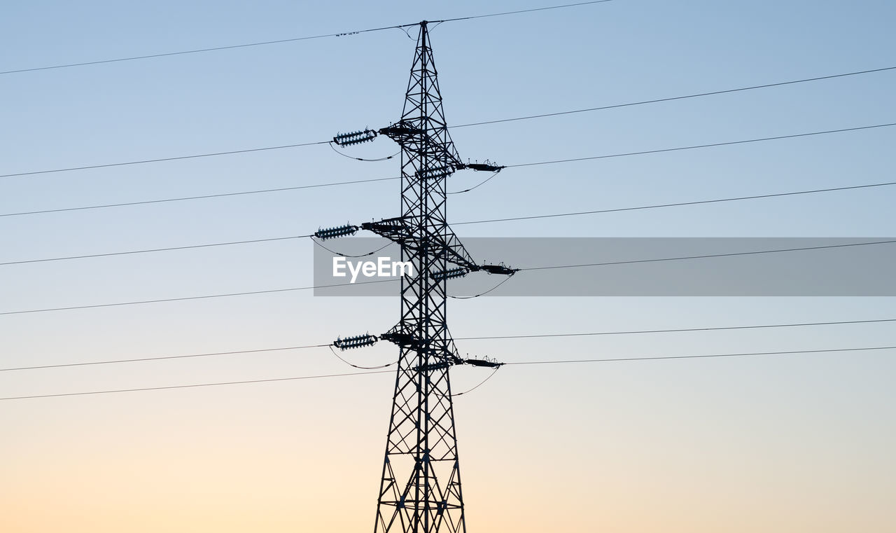 LOW ANGLE VIEW OF SILHOUETTE ELECTRICITY PYLONS AGAINST CLEAR SKY
