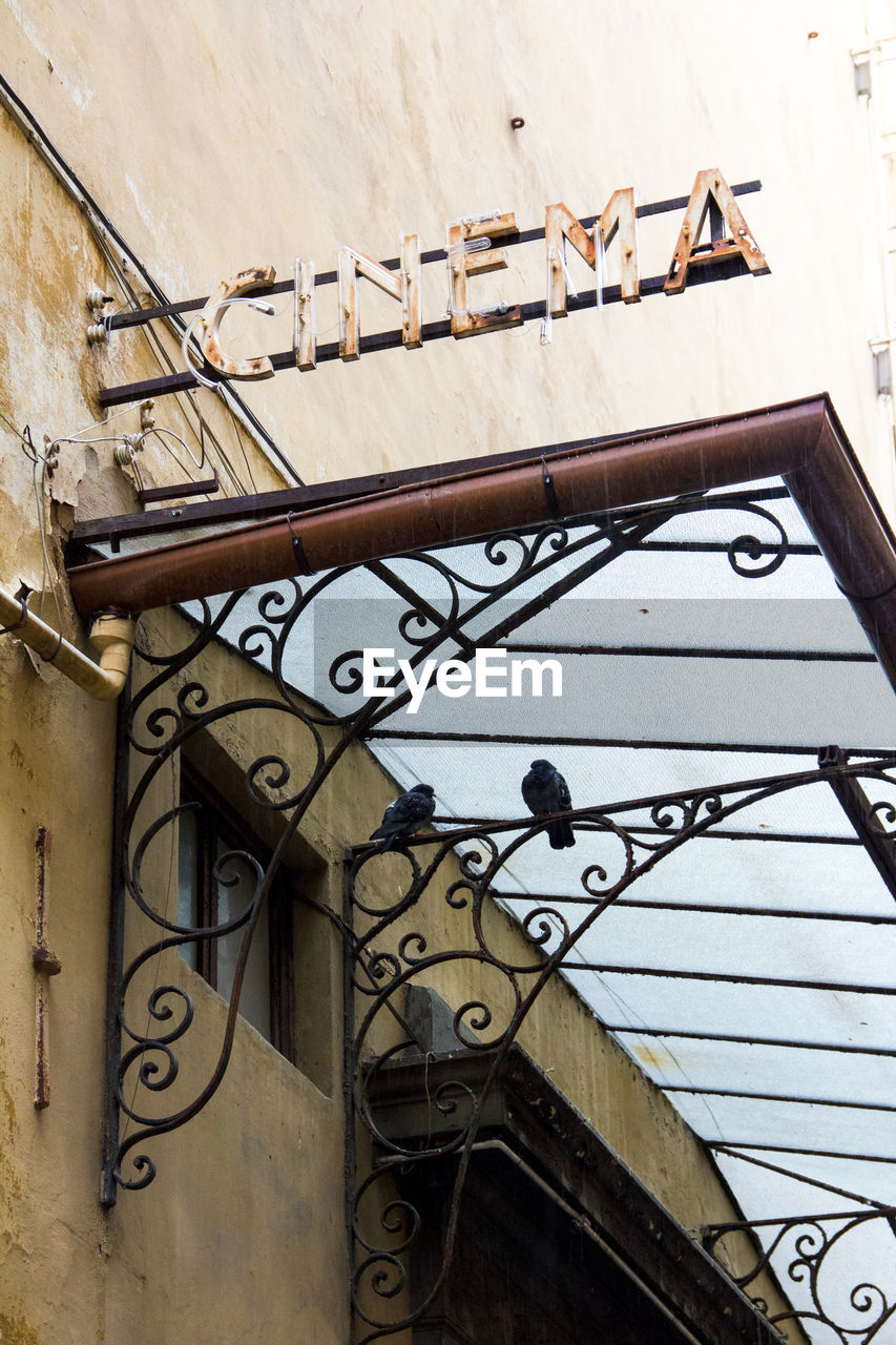 Low angle view of old cinema sign on wall