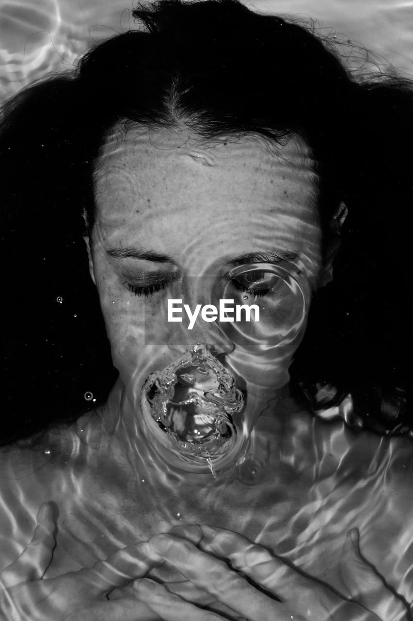 Close-up portrait of woman underwater, symbolism 