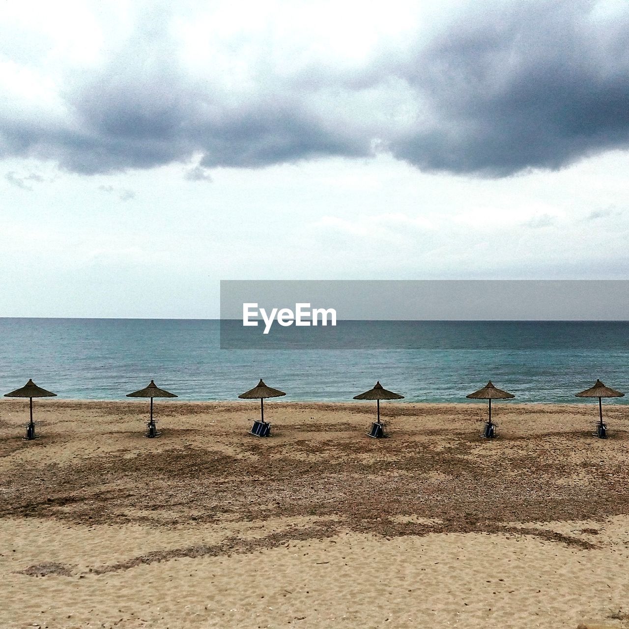 Scenic view of beach against cloudy sky