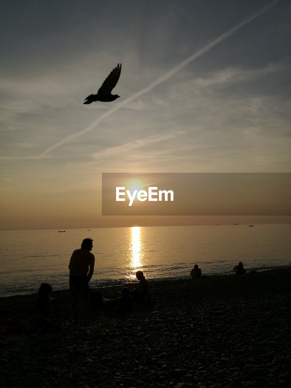 SILHOUETTE MEN FLYING OVER SEA AGAINST SKY