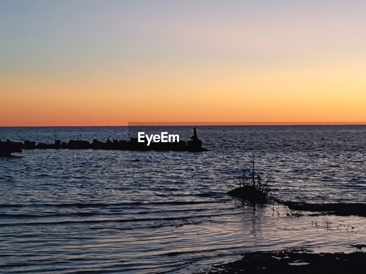 SCENIC VIEW OF SEA AGAINST SKY AT SUNSET