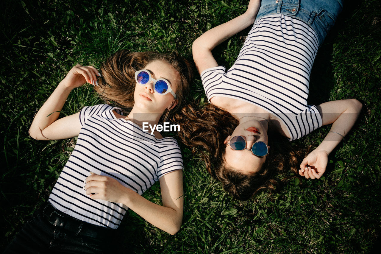 High angle view of friends lying on grass