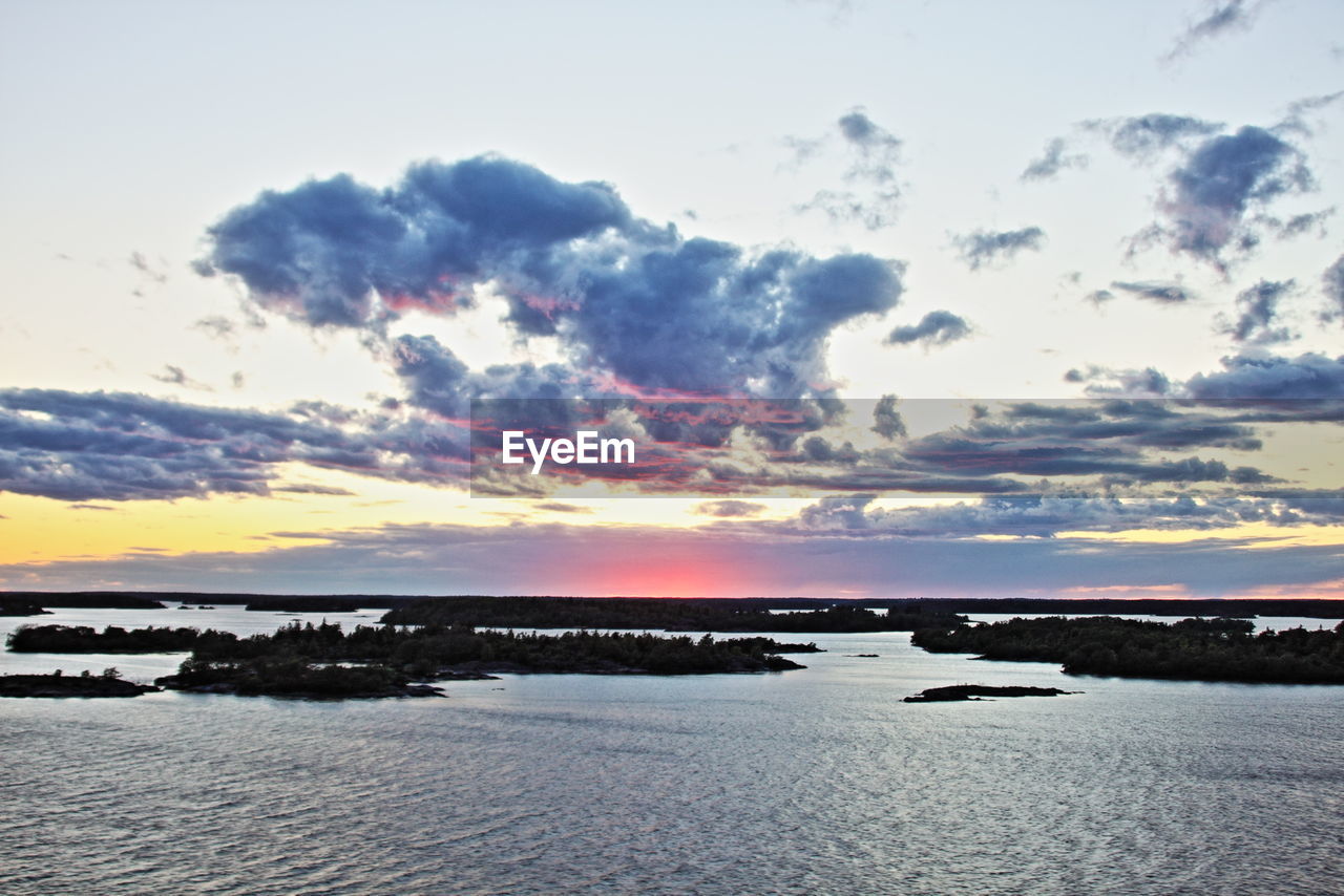 Scenic view of baltic sea against cloudy sky during sunset