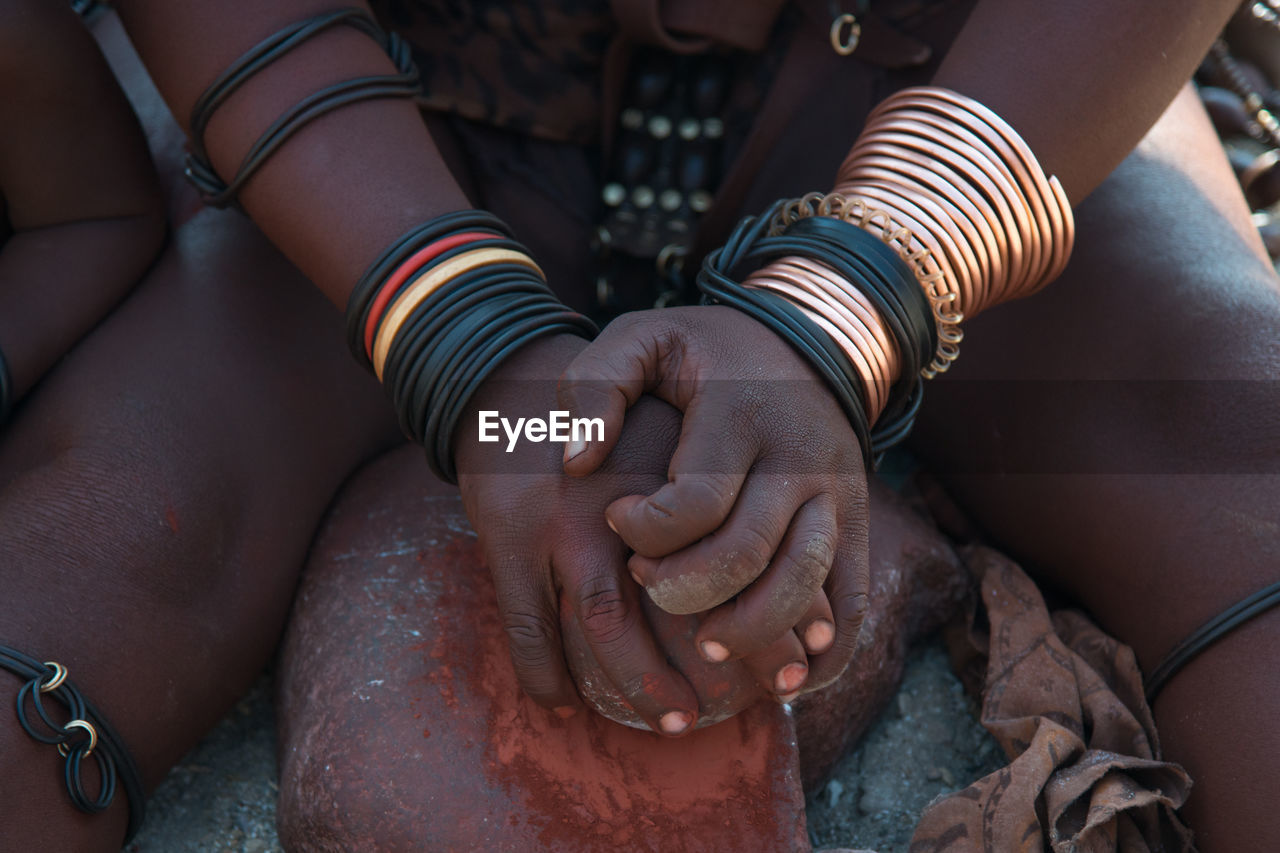 Unrecognizable woman of himba tribe with clay, clay is used to protect skin. epupa region, namibia.