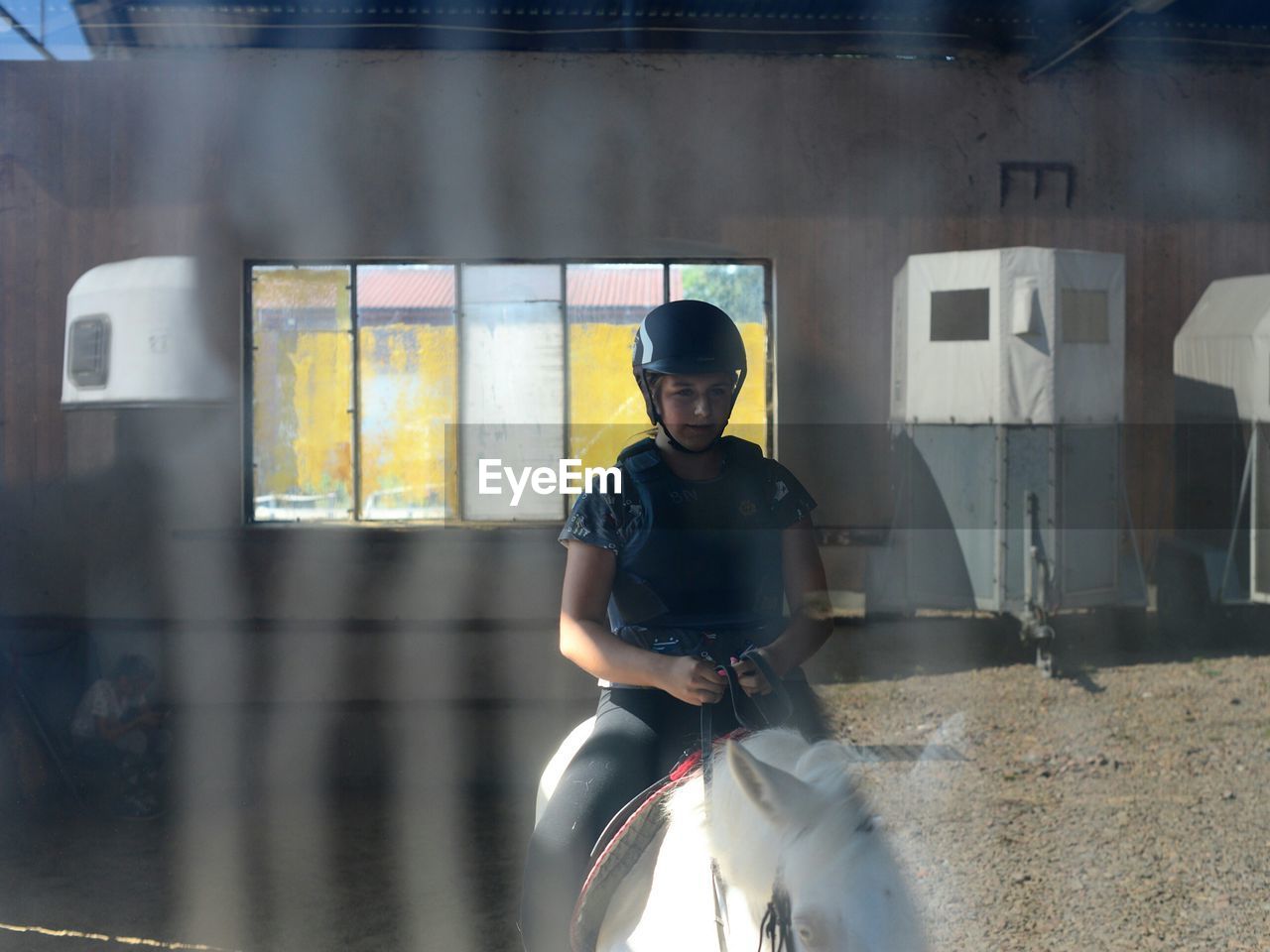 Woman sitting on horse in stable