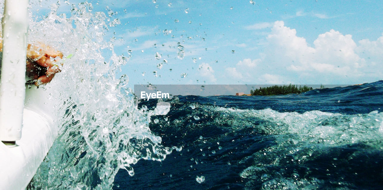 Cropped image of wave splashing on boat