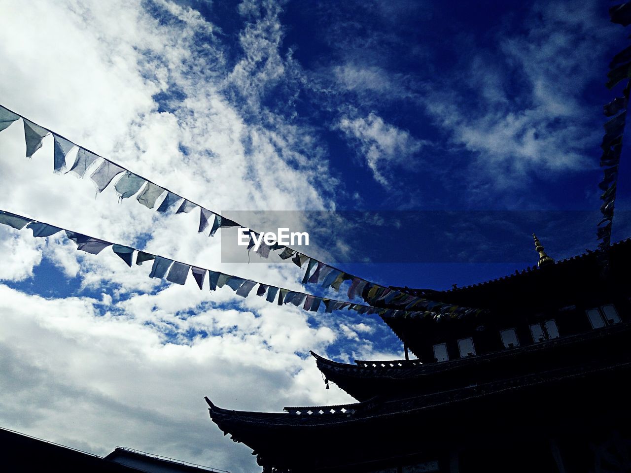 LOW ANGLE VIEW OF ROOF AGAINST CLOUDY SKY