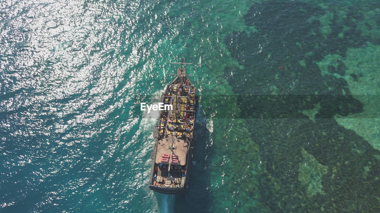 HIGH ANGLE VIEW OF PEOPLE SAILING IN SEA