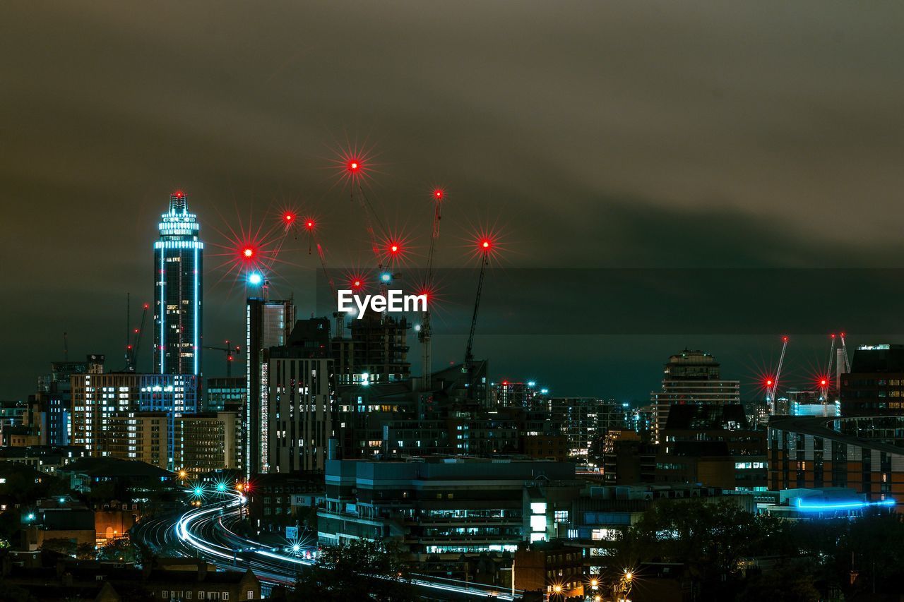 VIEW OF ILLUMINATED CITYSCAPE AT NIGHT