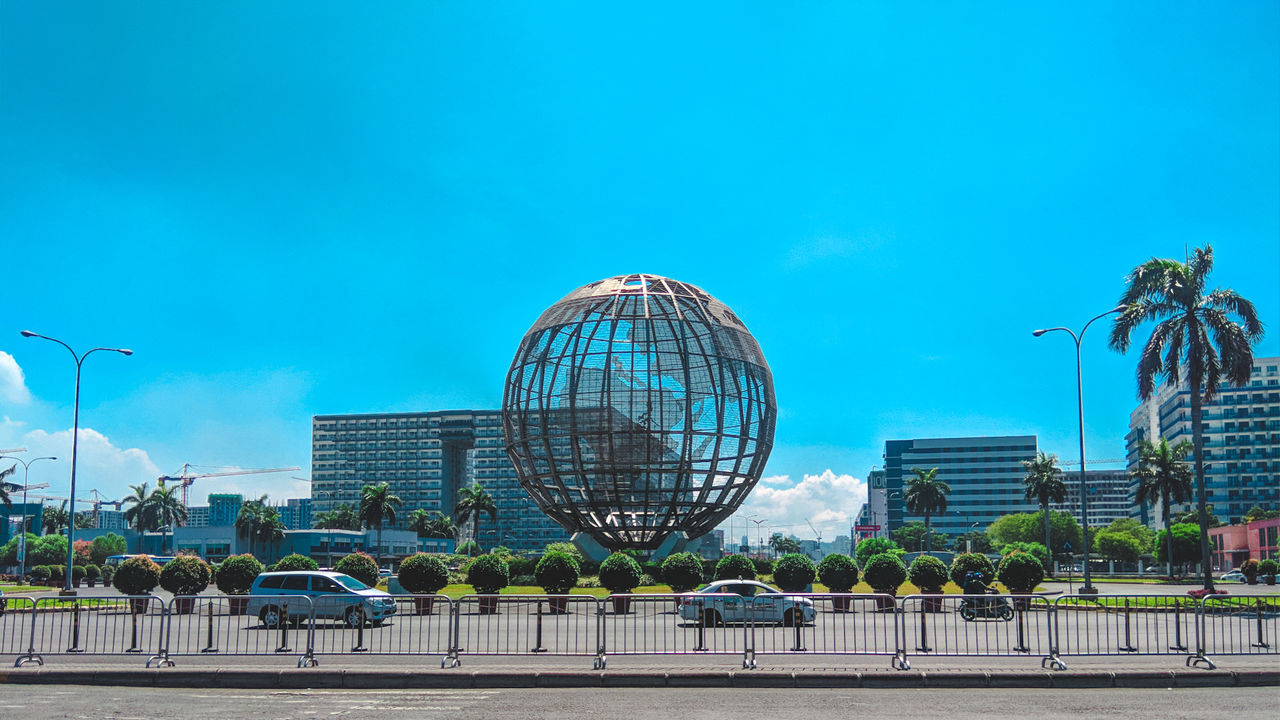 Statue in city against clear blue sky