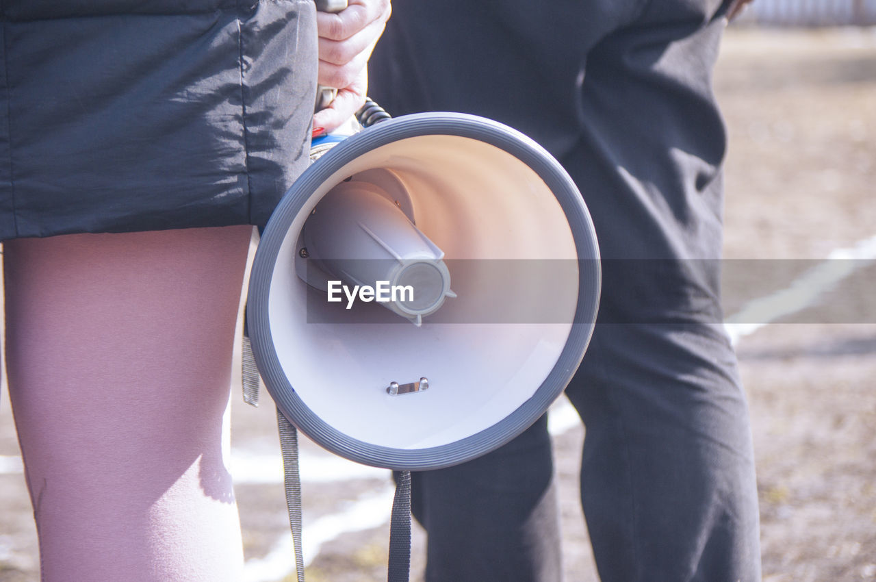 MIDSECTION OF WOMAN HOLDING HANDS