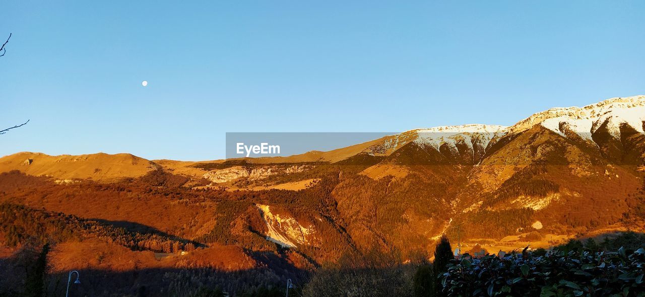 Scenic view of mountains against clear blue sky