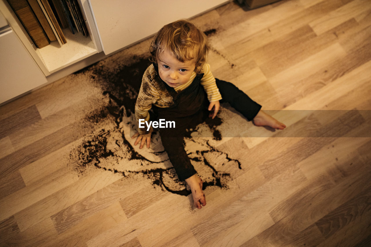 Boy sitting on floor in spilled coffee