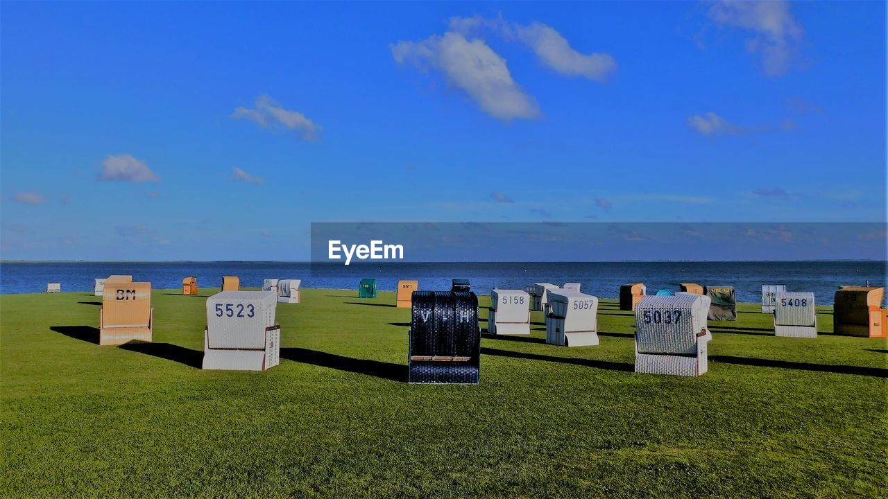 Hooded beach chairs at the coast of the north sea in büsumer deichhausen at a summers evening