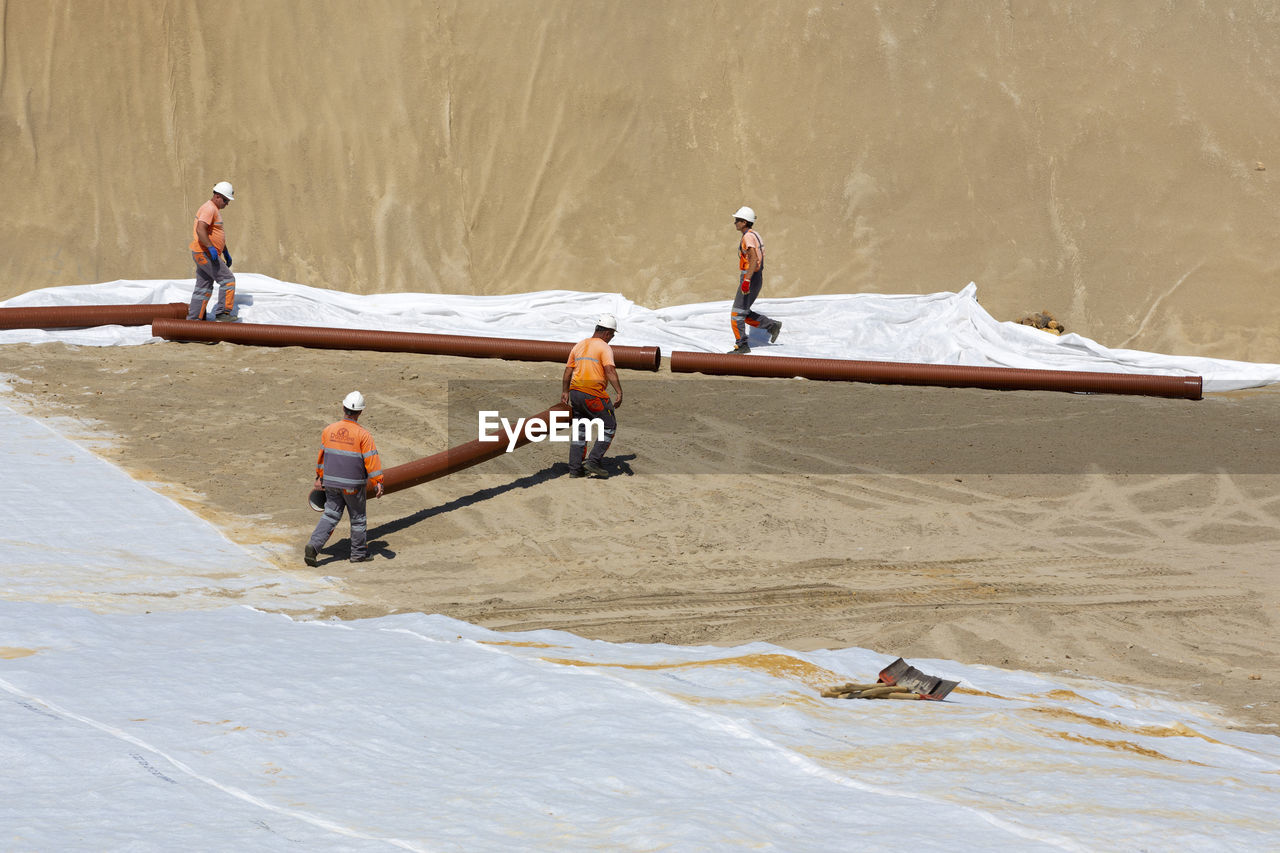 HIGH ANGLE VIEW OF MAN WORKING AT BEACH