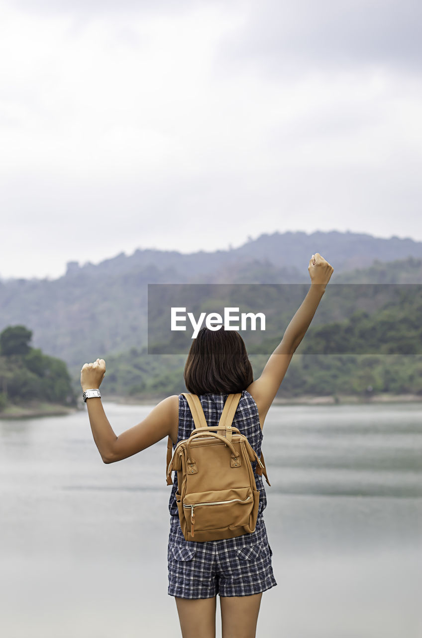 Woman clenching fists against lake