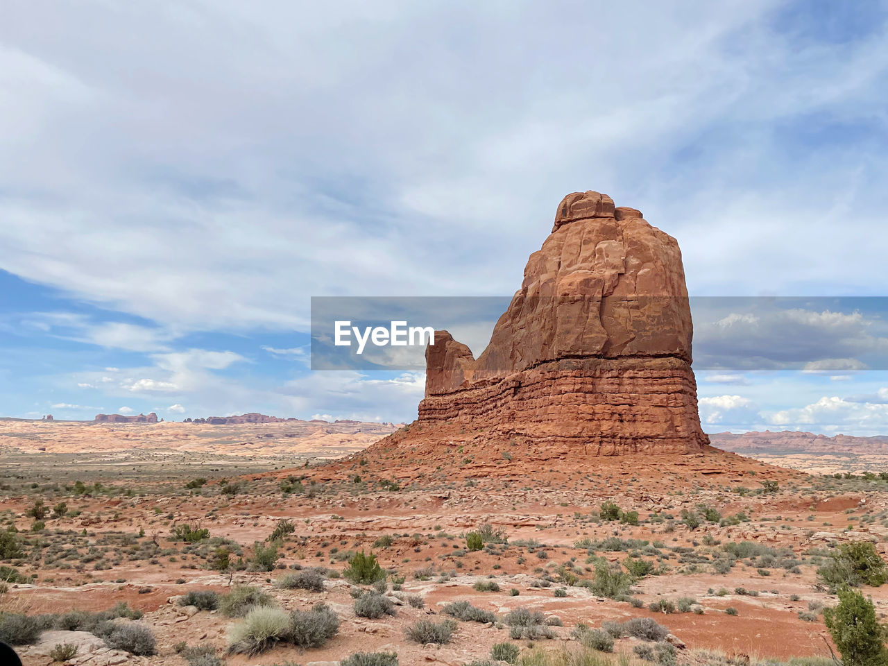 Rock formations on landscape against cloudy sky