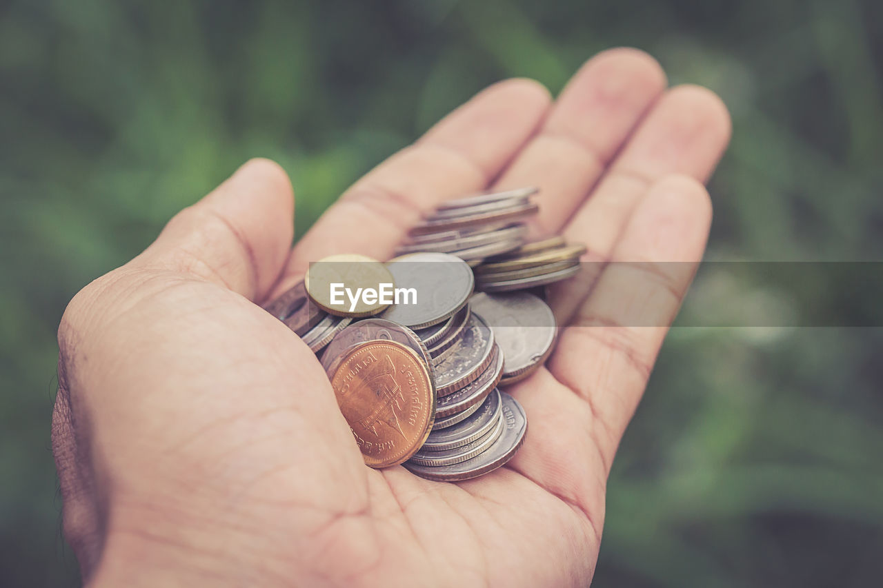 Close-up of hand holding coins