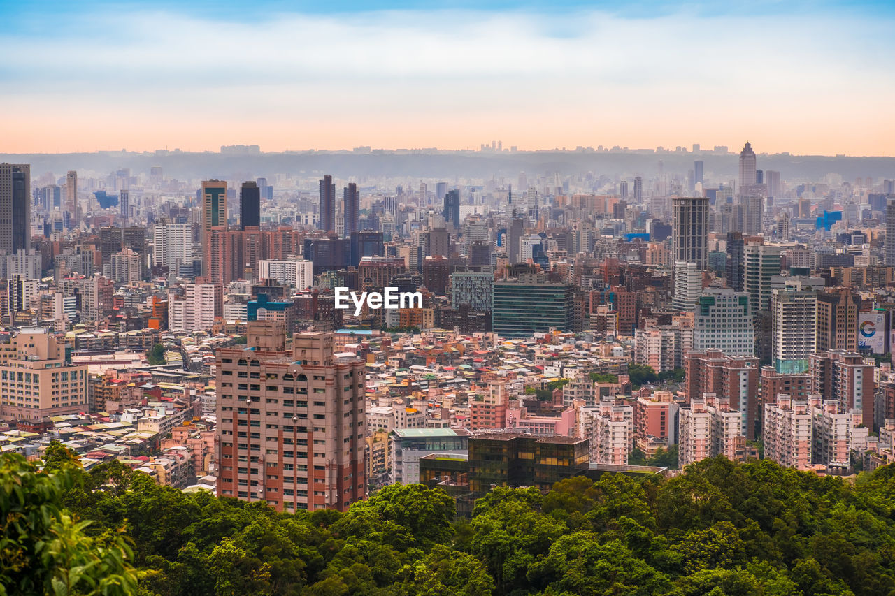 Aerial view of buildings in city against sky