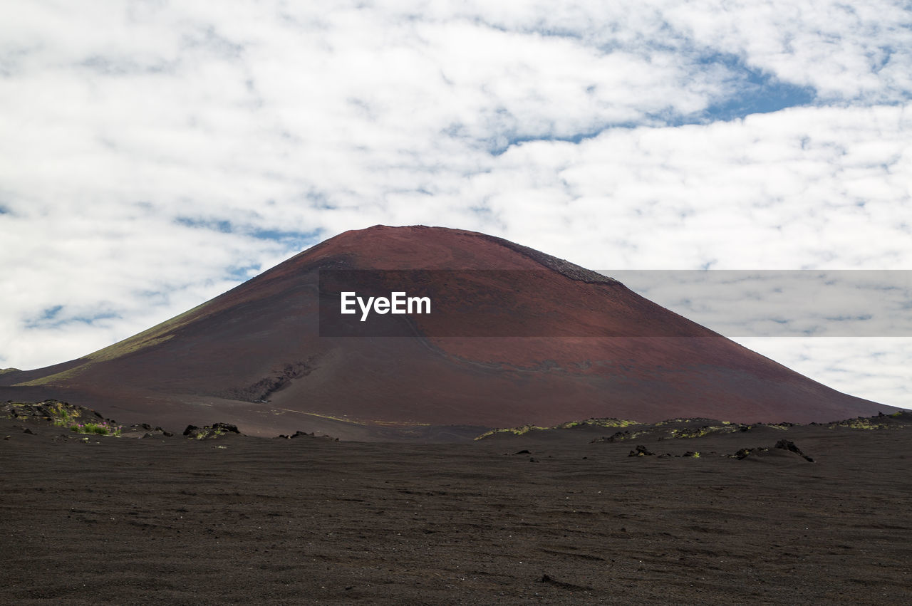 View of desert against cloudy sky