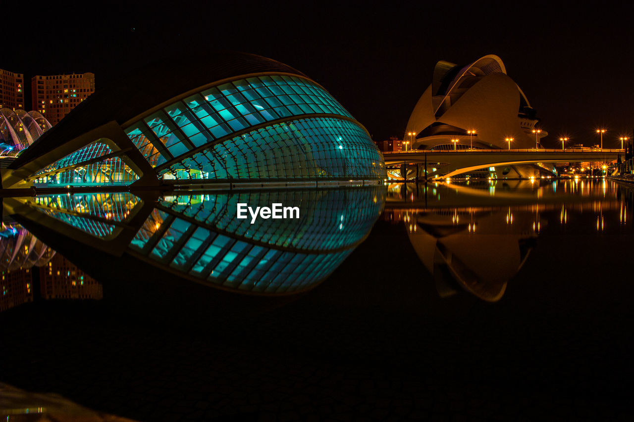 REFLECTION OF ILLUMINATED FERRIS WHEEL IN WATER