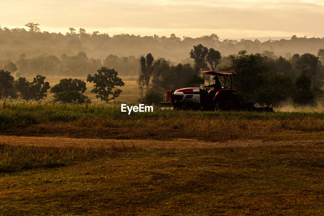 TRACTOR ON FIELD AGAINST SKY