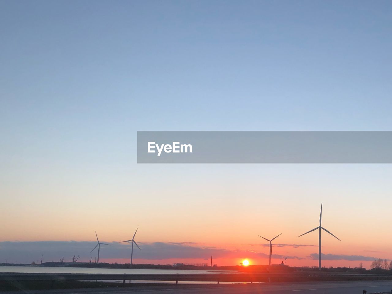 WINDMILL ON FIELD AGAINST SKY DURING SUNSET