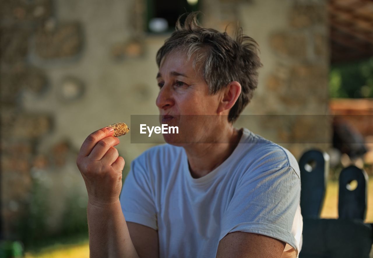 Portrait of mature woman holding homemade cookie