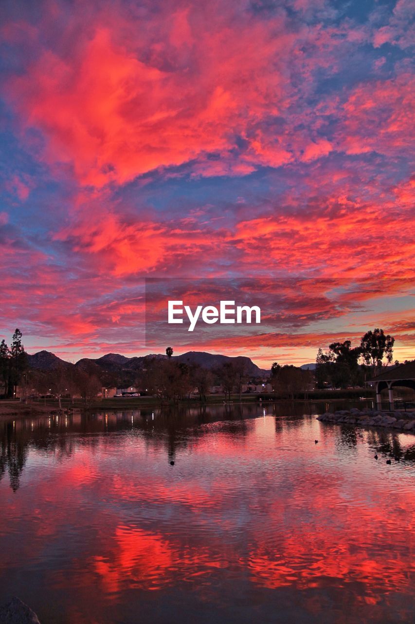 SCENIC VIEW OF LAKE AGAINST ROMANTIC SKY DURING SUNSET