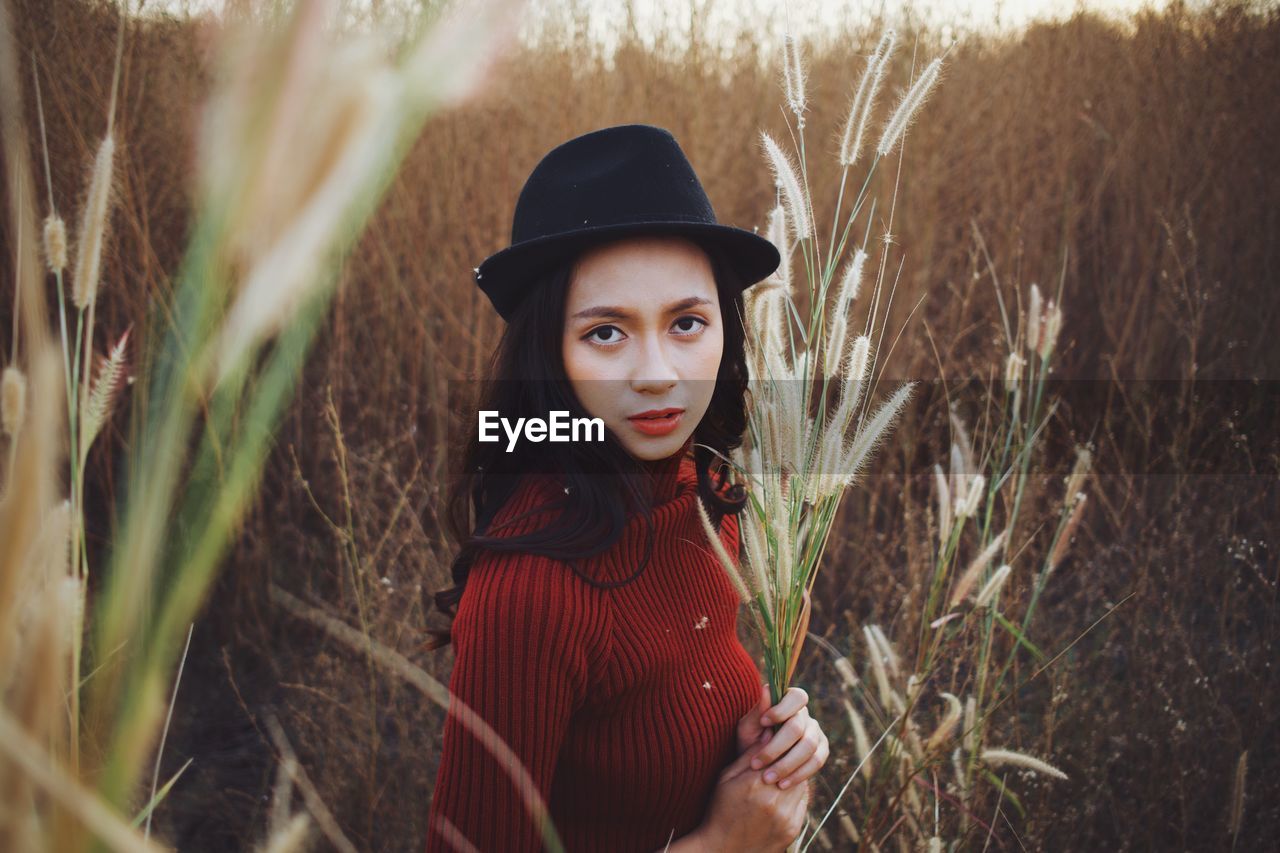 PORTRAIT OF YOUNG WOMAN WITH HAT ON FIELD