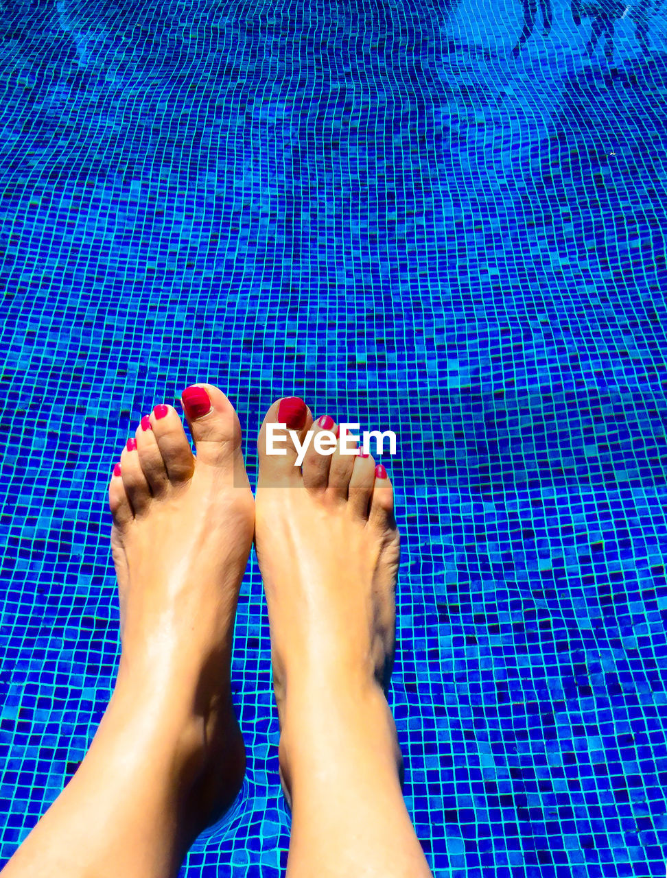 Low section of woman's legs in swimming pool