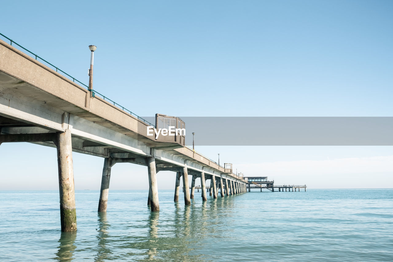 Pier over sea against clear sky