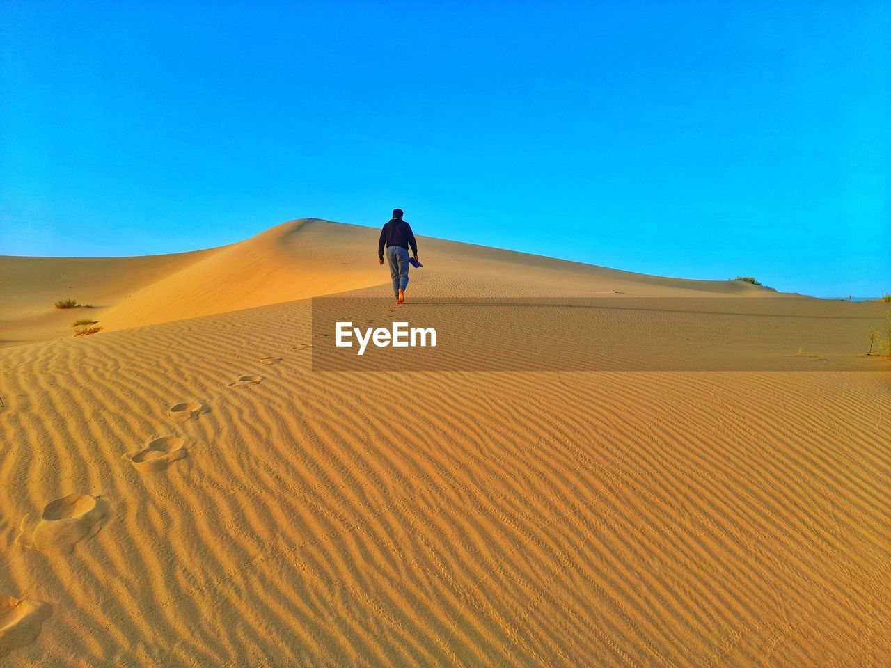 Walking on sand dunes on sahara desert of algeria