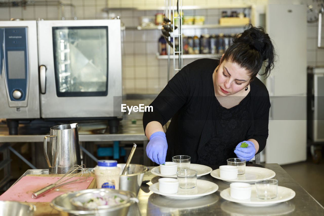 Woman preparing food in restaurant kitchen