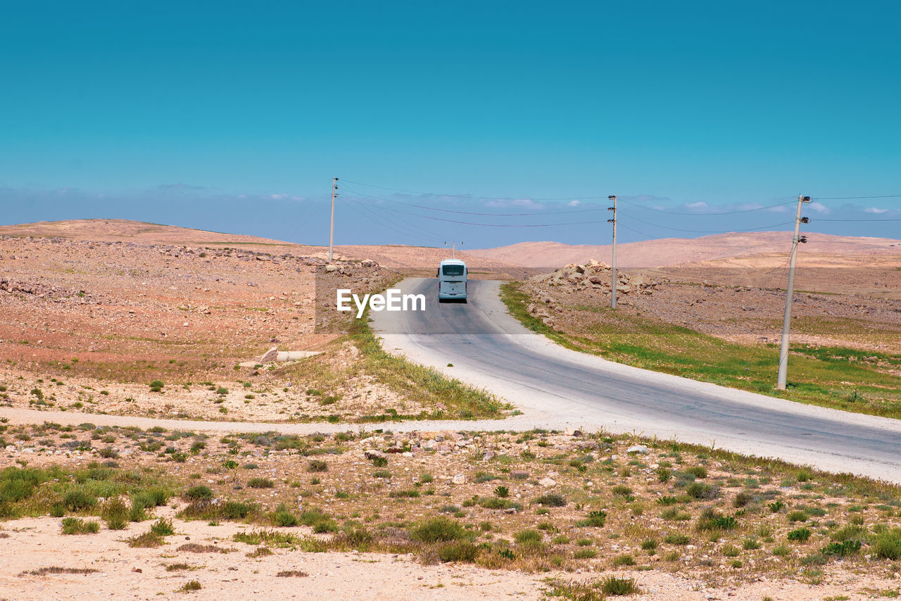 CAR ON ROAD AGAINST SKY