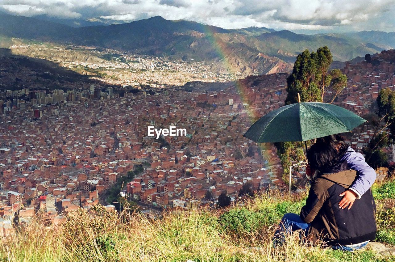 People sitting on mountain against sky