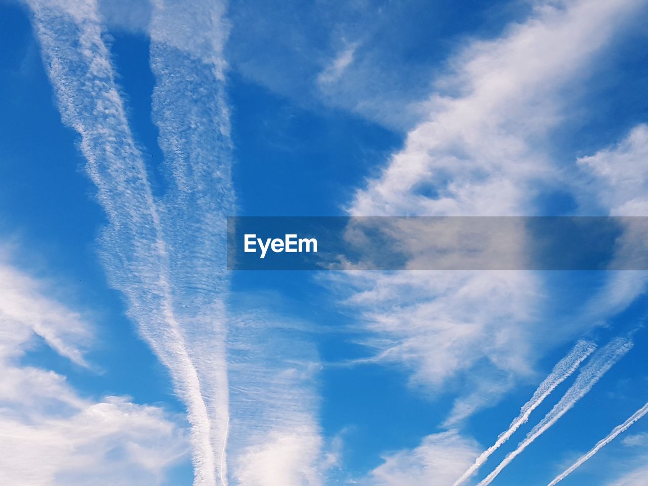 LOW ANGLE VIEW OF VAPOR TRAILS AGAINST BLUE SKY