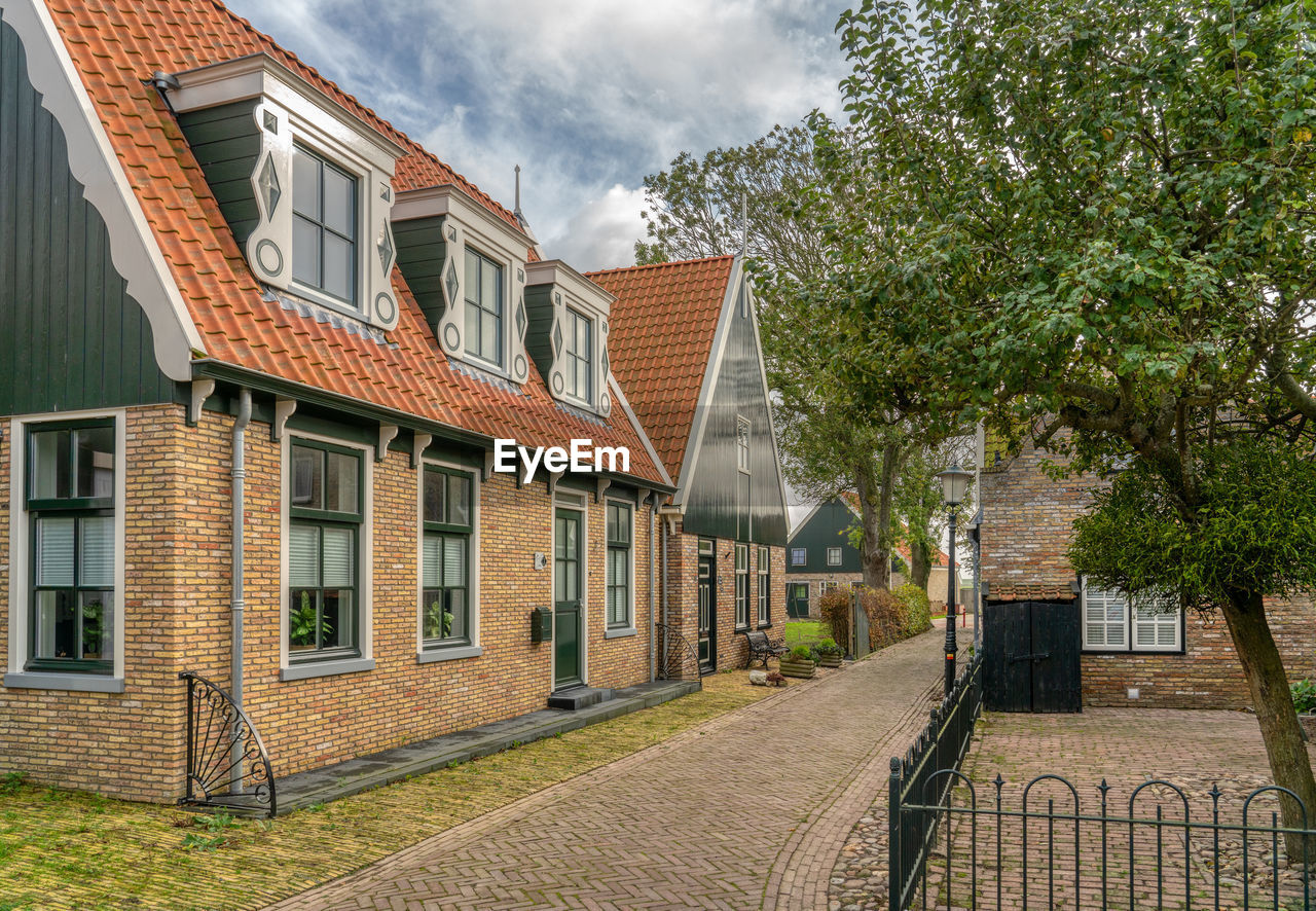 Residential buildings by street against sky