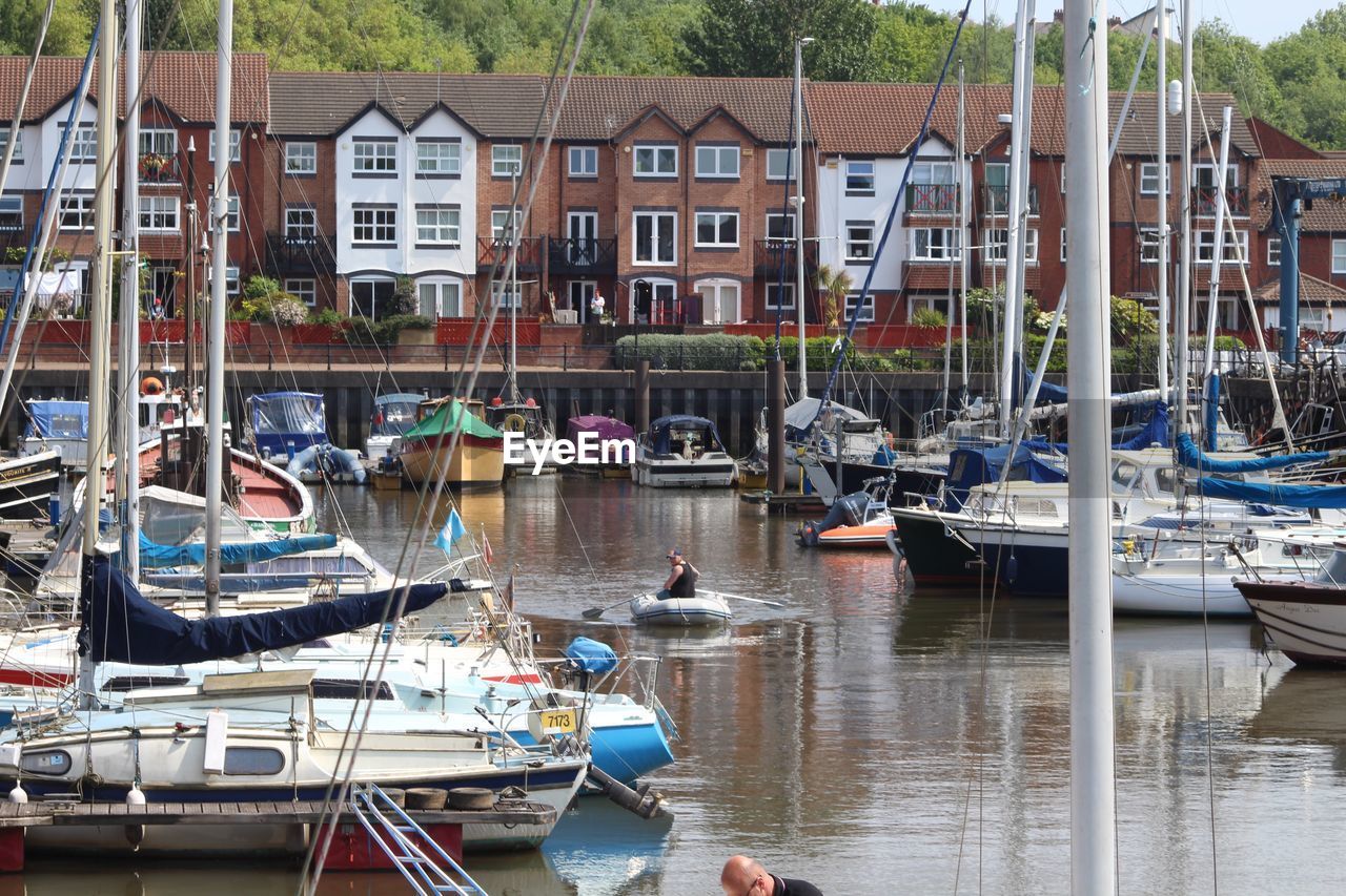 Boats moored in canal by houses