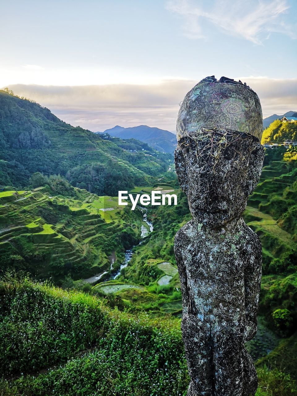 Statue against landscape and sky