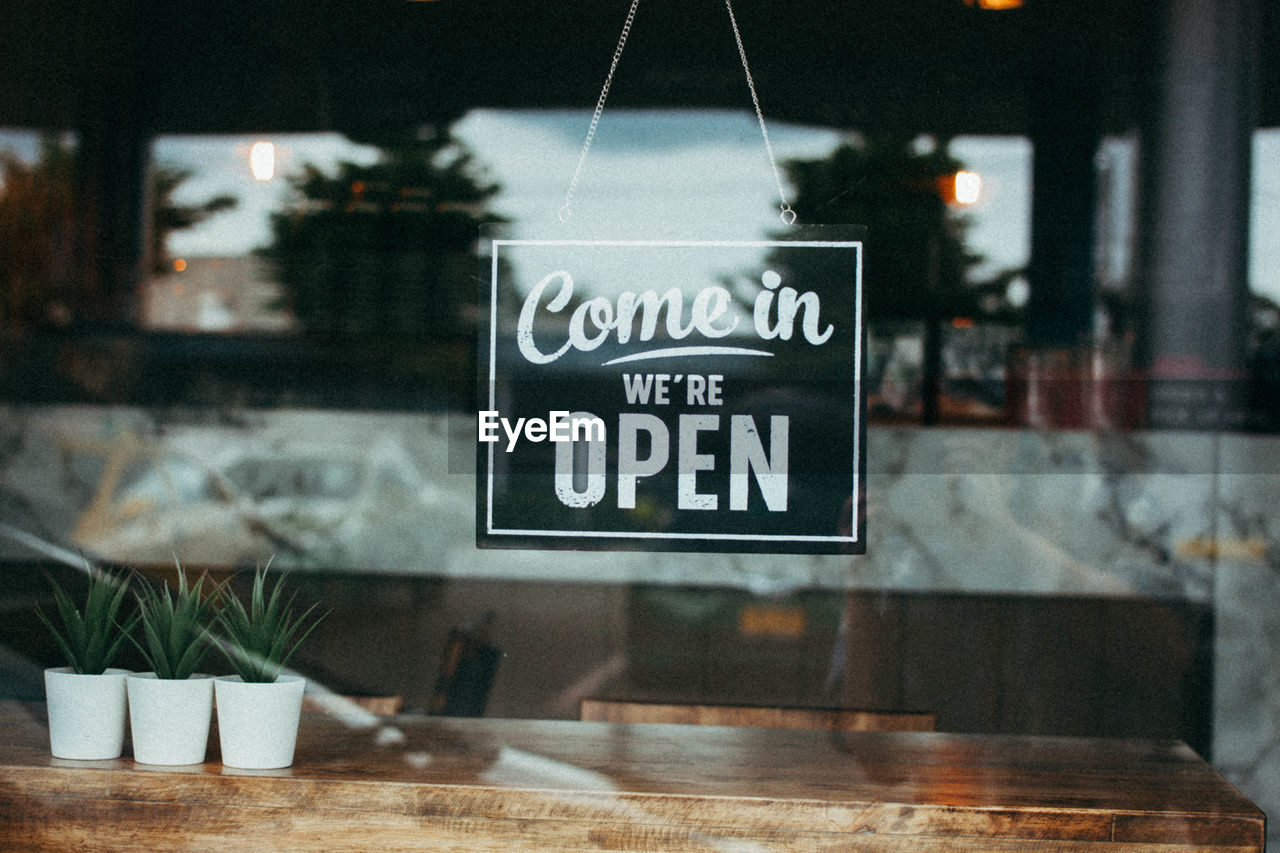 Close-up of information sign on glass window at restaurant