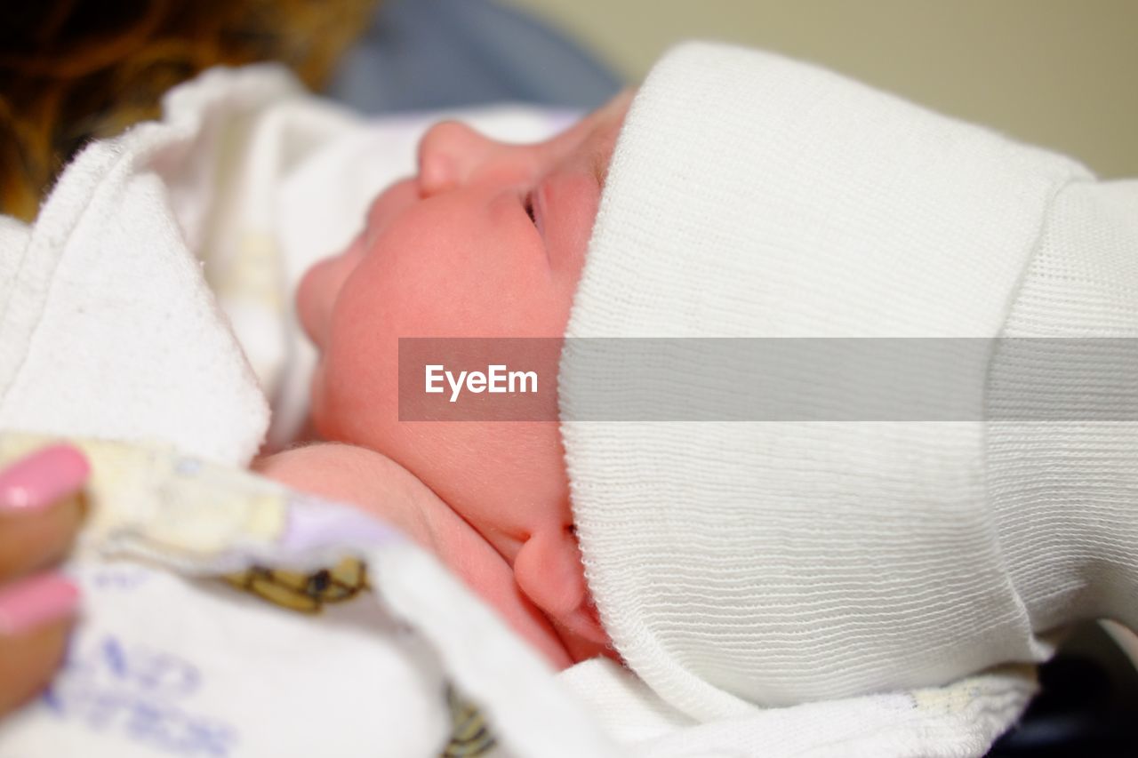 CLOSE-UP OF BABY BOY SLEEPING IN BED