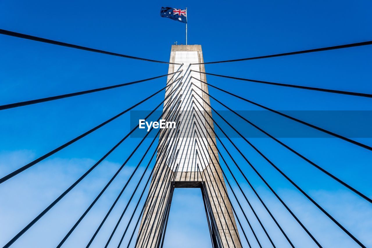 Low angle view of suspension bridge with australian flag against sky