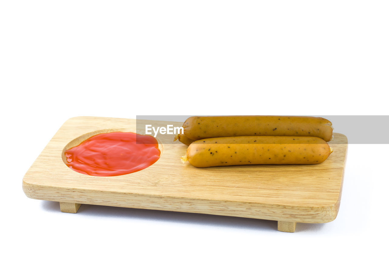 Close-up of cake on cutting board against white background